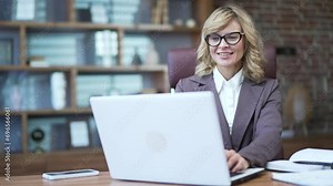 A mature woman, a financier, or entrepreneur, teacher, mentor, tutor work with a laptop computer. Business female typing browsing chatting in office. concept technology, accounting, online banking