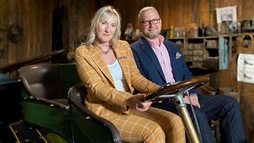 Caroline Hawley gets behind the wheel of an antique automobile.