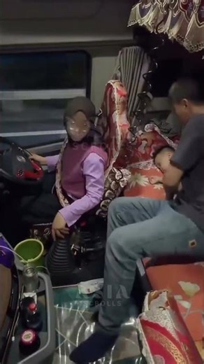 Chiniese couple helping each other while driving truck