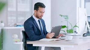 Businessman using digital tablet, typing on computer keyboard and planning global business strategy. Confident professional sitting alone in office, multitasking and using technology to innovate idea