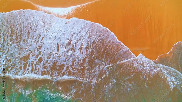 A big sea wave rolls onto the shore. Top view of a beautiful sandy beach. Sea coast from the air. View of a sandy beach. Aerial video of a sea wave. Ocean and beach. Copy space.