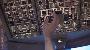 Detail shot of airline pilot switching various controls on an overhead panel in a jumbo jet cockpit. Originally recorded in 4K. Stock Video