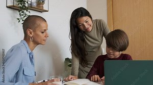 Lesbian couple helping their non-binary child to do homework at home