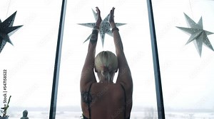 Girl meditating while sitting in lotus pose. She is very calm, focused and concentrated practicing to meditate. Female raise her hands above head and do a deep breathe in while taking hands down.