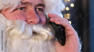 Portrait of Santa Claus talking on smartphone. Santa communicates with children on the phone Stock Video