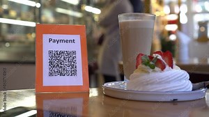 QR code touch-free payment display in the retail store. To use a QR code payment the consumers scans the QR code displayed by the merchant with their phones to pay for their goods. Shopping