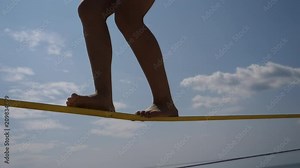 Young girl legs outdoor training walking and balancing on slackline rope sport activity