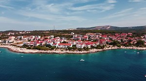 Aerial view of Rogoznica, coastal town in Croatia. Residential buildings with red rooftops and turquoise sea. Mediterranean architecture, summer tourism and seaside real estate concept