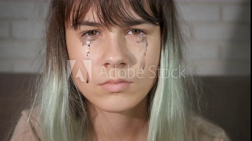 Crying teen girl in lonely. A modern upset teen girl with crying face think about her problems in the living room.