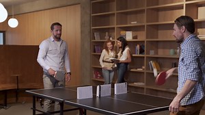 Two coworkers take a break from work by playing ping pong | Free Stock Video Footage