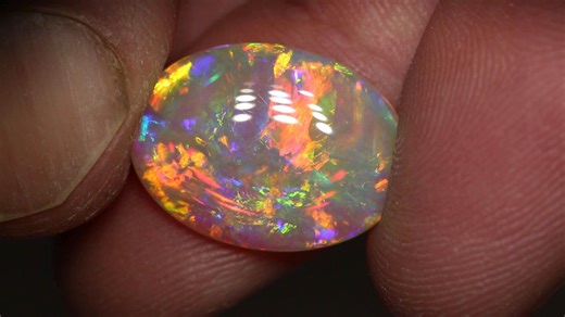 This exceptionally bright and colorful Andamooka Crystal Opal has a mesmerizing 3D play of color that dazzles the senses. ⚡️ Blasts of fiery orange and gold against the cool green, purple, and blue work in perfect harmony. 🌈 7.05ct gem crystal opal 19.1x14x3.9mm https://blackopaldirect.com/product/opal/crystal-opal/7-05-ct-gem-crystal-opal-19-1x14x3-9mm/ | Black Opal Direct