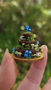 Blue and green toadstools, moss and leaves on miniature polymer clay cakes. The blue mushrooms are inspired by New Zealand's native #werewerekokako, which are also the only fungi to feature on banknotes. #miniature #polymerclay #miniaturefood #toadstools #mushrooms #fungi #moss #entolomahochstetteri | Moon Lighting