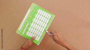 Punching holes in school schedule planner with professional tool, paper arts and crafts