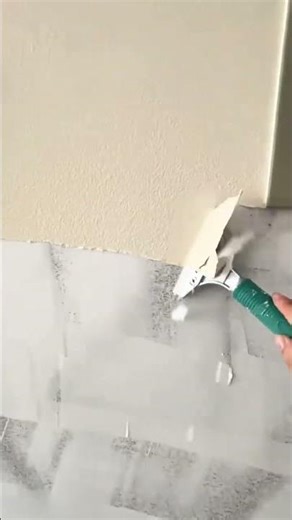 Removing old wallpaper with a metal scraper to prepare the wall for renovation
