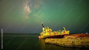 Milky Way time lapse over Coral Bay, Cyprus with a shipwreck on a rocky coastline