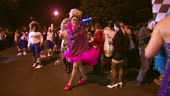 Shot of men's in drag costumes strut and pose during high heel race...
