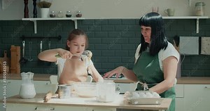 Mother and daughter cooking in Kitchen to Bake Cookies. Mom and daughter bake pizza in the kitchen together