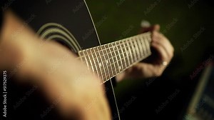 A man plays an acoustic guitar. Close-up hand on the fretboard, slow motion. Guitar lesson, teacher shows chords