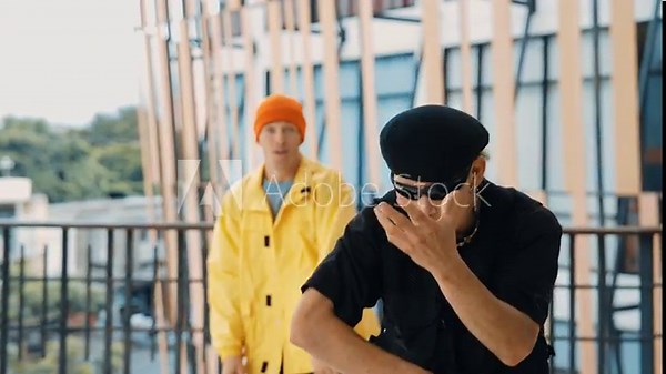 Two professional hipster dance together and move to hip-hop music at mall corridor with city view. Diverse choreographer practice break dance foot step. Street dance. Outdoor sport 2024. hiphop.