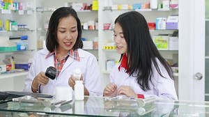 Pharmacist scanning barcode information details medicine and patient buying medicine in pharmacy store Thailand 4k footage video