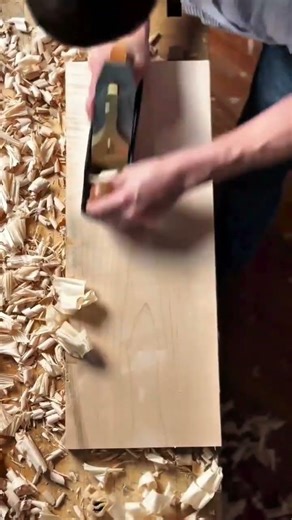 Planing the surface of a wooden board with a hand plane until smooth and even for neat carpentry