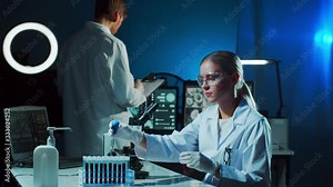 Medical scientists working in lab. Doctor teaching intern to make blood analyzing research. Laboratory tools: microscope, test tubes, equipment. Coronavirus, bacteriology, virology and health care.