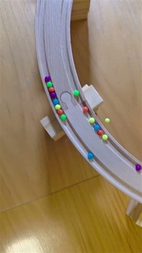Small Colorful Beads on a Wooden Marble Runway