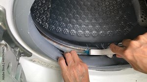 Cleaning washing machine. Use a brush to clean the edge of the washer drum. Stock Video