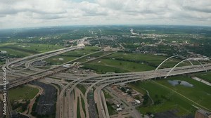 Tilt down reveal of large and complex multilane highway interchange. Multilevel transport construction. Busy road in rush hours. Dallas, Texas, US.