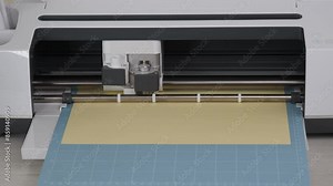 Smart Cutting machine for home using. Plotter, digital flatbed cut out details on yellow cardboard on blue mat. DIY manual paper craft, making gifts, cards for family. Creative Hand crafting project