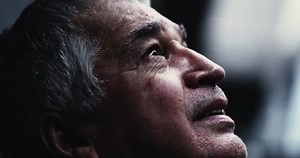 Spiritual older man putting hand on chest.