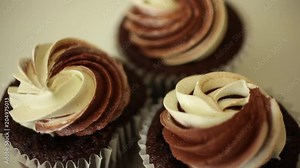 Extreme close up of three chocolate mini cupcakes with a shallow depth of field and a roll focus.