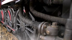 Shot of steam train wheels. Steam coming from below.