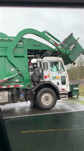 Newbergs Peterbilt 520 front loader dumping a dumpster