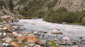 Water stream of rapid river quickly flowing in mountain valley. Slow motion