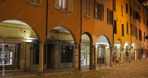 Cinematic view of famous and historic architecture, buildings and city center in Cesena at night in Northern Italy.
