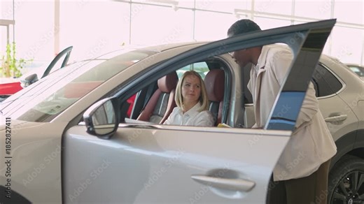 Car salesman advising a female client in a dealership