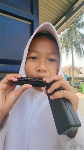 Aulia learns how to play the harmonica
