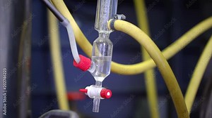 Production of perfumery essences by steam distillation in a distillation cube in a small alpine village. A mixture of water and aroma is condensed in a special glass flask. Real people.