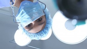 Doctor looks down at patient with stethoscope