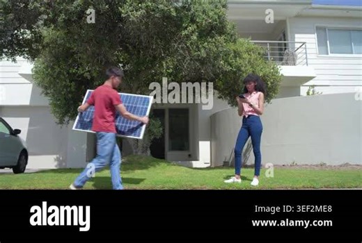 Asian man bringing solar panel, placing at curb for install while woman checking phone, copy space. Photovoltaic, module, installation, residential, outdoor, driveway, tree Stock Video Footage - Alamy
