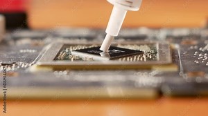 Close-up of applying thermal paste to a computer microprocessor for effective cooling. Maintenance and repair of computer processors. Repair of household appliances. Selective focus,