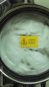 Washing machine turning close-up. Scene. Industrial washer machine working. Close-up of laundry clothes in industry washing machine