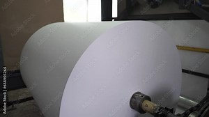 Paper and pulp mill. Process of various paper products manufacturing indoors. An empty quiet industrial wallpaper and paint factory with giant industrial wall paper rolling machines.