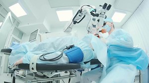 Surgeon looking into the microscope at the eye of female patient at the operating room. Doctor using microscope during eye surgery process, treatment of cataract and diopter correction. 5