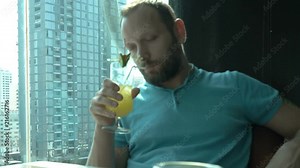 Man sitting in pub and looks very drunk while drinking alcoholic drink