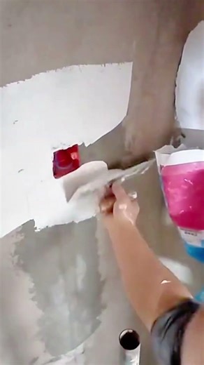 Smoothing fresh white wall surface using plaster compound for clean and even home interior finish