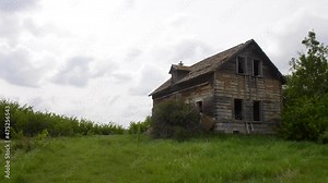 Exploring the ruins of an derelict abandoned rural farmhouse in an overgrown field of the Alberta prairies in western Canada.
