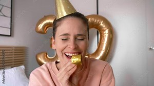 Woman with a party horn blower and party hat