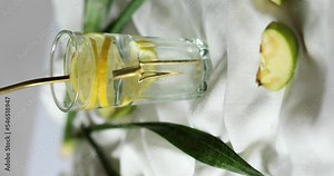 Vertical video rotation fresh cool lemon infused water, cocktail, detox drink, lemonade in a glass with metal eco cocktail tube, nutrition diet concept
